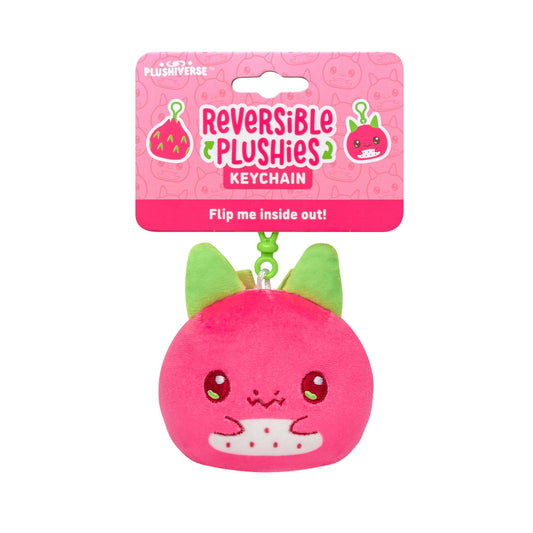 Reversible Plushiverse Dragonfruit plushie keychain packaging, featuring a round, pink plush with a cute face and green ears, labeled “flip me inside out!” on a pink background with fruit icons.