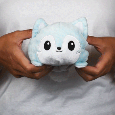 A person with a TeeTurtle Reversible Wolf Plushie.