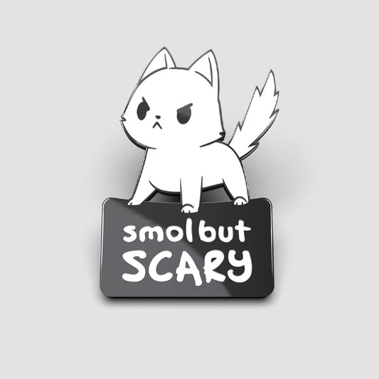 A white cat with Smol But Scary Pins from TeeTurtle, wipe clean.