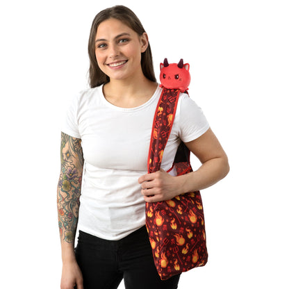 A woman holding a TeeTurtle Devil Cat Plushie Tote Bag.