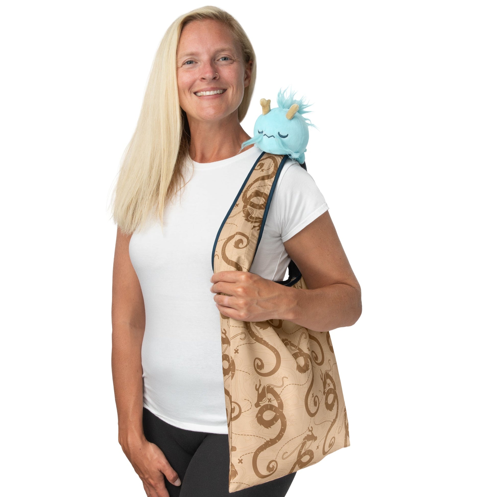 A woman carrying a TeeTurtle Fantasy Dragon Plushie Tote Bag.