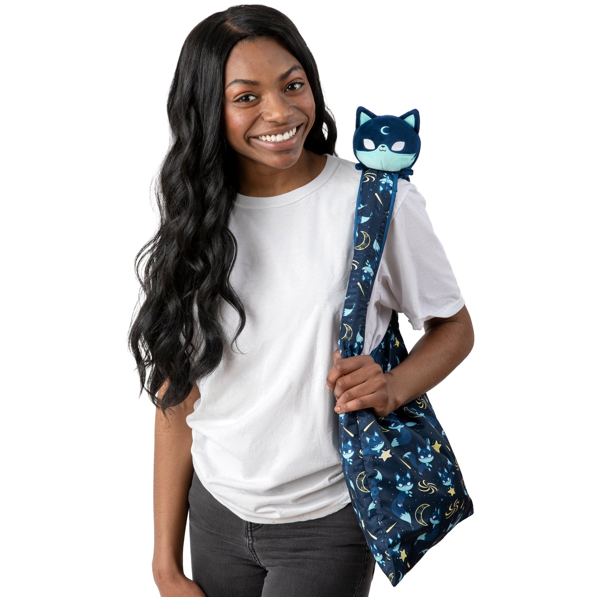 A young woman holding a TeeTurtle Celestial Fox Plushie Tote Bag while also showcasing a storage pouch.