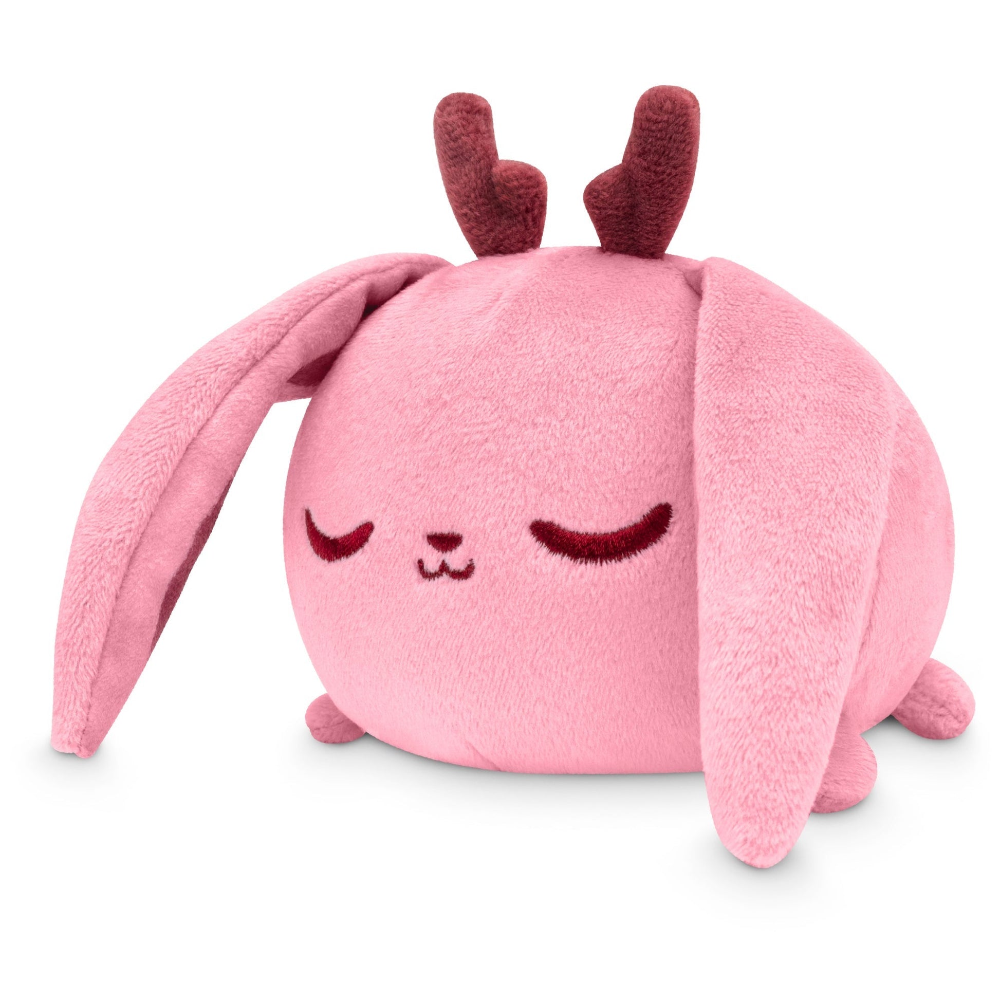 A pink TeeTurtle Plushiverse Fearsome Jackalope plush toy rabbit with long ears and a content, sleeping facial expression, isolated on a white background.