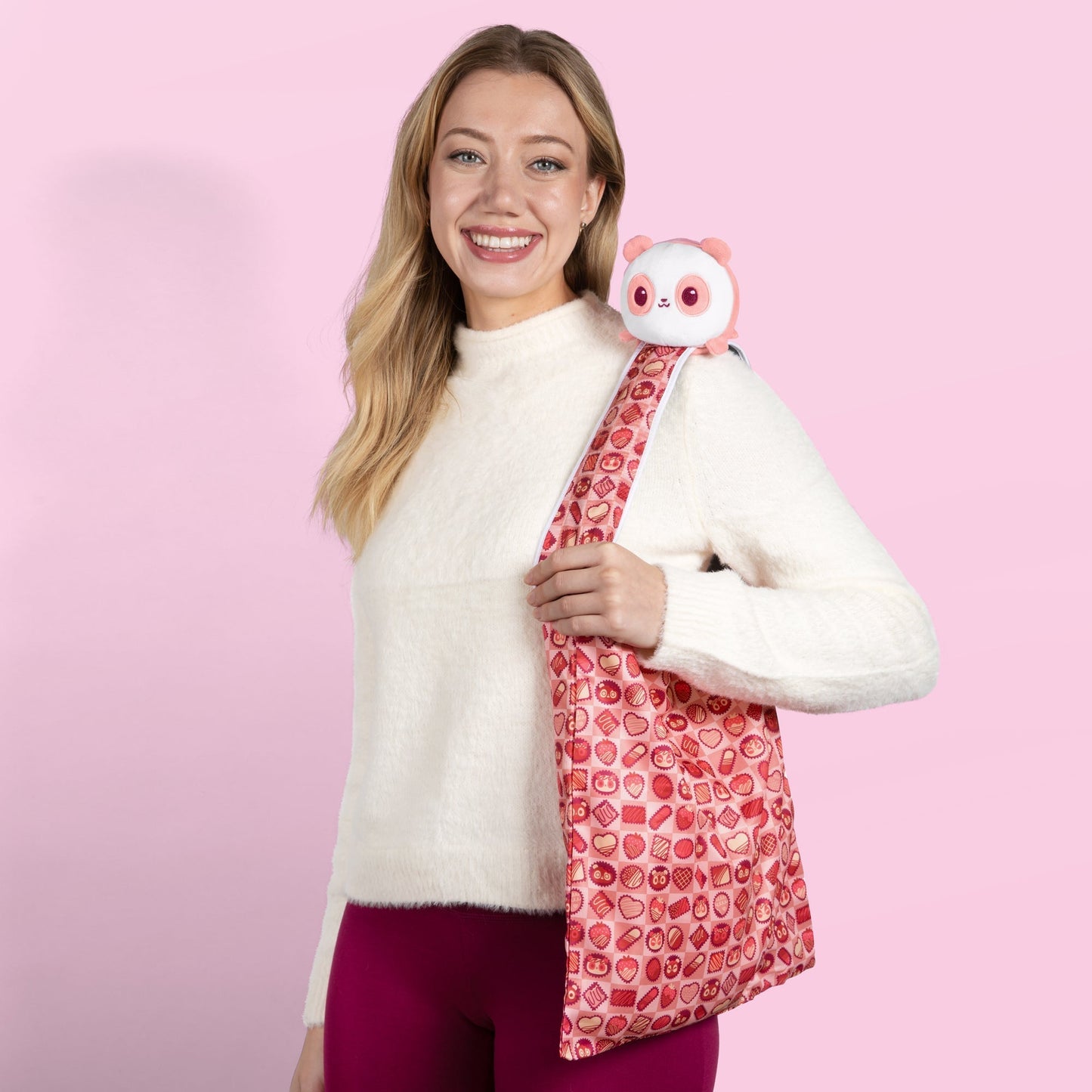 A woman carrying a TeeTurtle Plushiverse Choco-Panda Plushie Tote Bag with a plush owl inside.