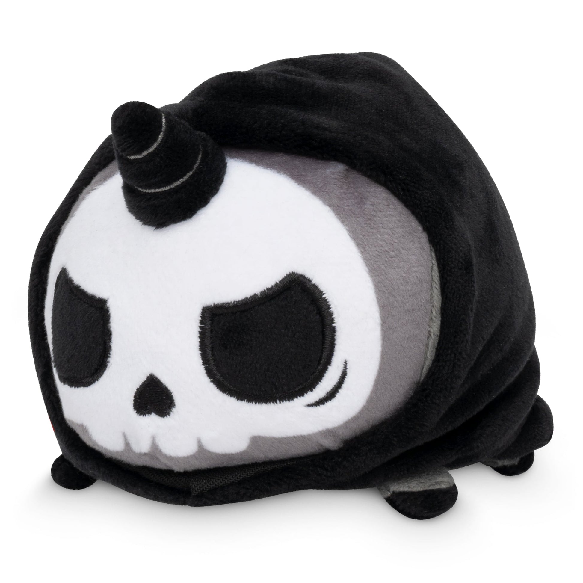 Plushiverse Unicorns of the Apocalypse Plushie Tote Bag designed as a skull with a unicorn horn, wrapped in a black blanket made from recycled plastic bottles, featuring large eyes and small feet visible.