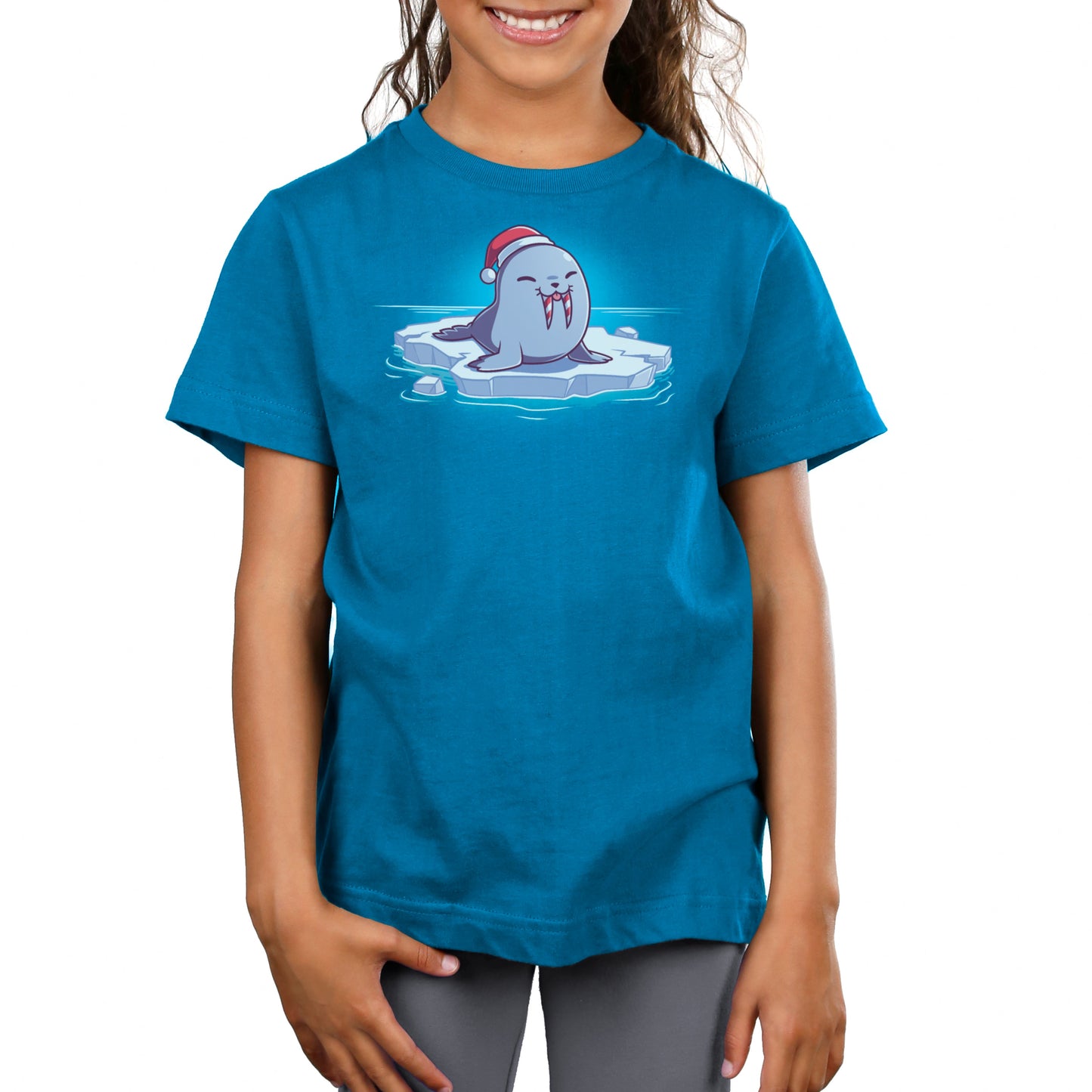 Premium Cotton T-shirt_TeeTurtle Sweet Tooth Cobalt Blue t-shirt featuring an illustration of a smiling walrus wearing a Santa hat, sitting on a floating ice. It's tusks are striped with red and white making them look like candy canes. It's also sticking out it's tongue. 