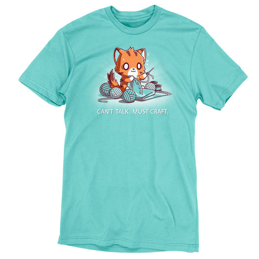 Premium Cotton T-shirt_Teeturtle Can't Talk. Must Craft caribbean blue t-shirt featuring a cat knitting with multiple yarn balls around and a concentrated expression. Text below reads 