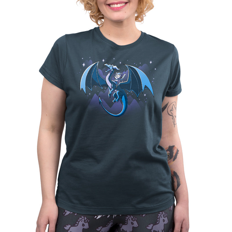 Premium Cotton T-shirt_TeeTurtle Dragon Rider denim blue t-shirt featuring a dragon with large wings flies through a night sky with mountain silhouettes and stars in the background, carrying a person in armor and a hood on its back.