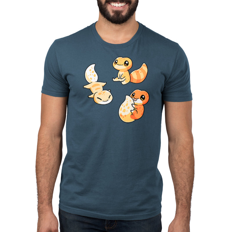 Premium Cotton T-shirt_TeeTurtle Lil Geckos denim blue t-shirt featuring three Lil' Geckos with varying yellow and orange patterns, sitting.