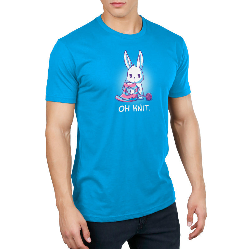 Premium Cotton T-shirt_Teeturtle Oh Knit Cobalt Blue featuring a white rabbit looking distraught. It's holding two knitting needles attached to a blue and pink striped scarf that has a large hole in the middle. There is a ball of pink yarn trailing off to the side and text beneath it that says "Oh knit."