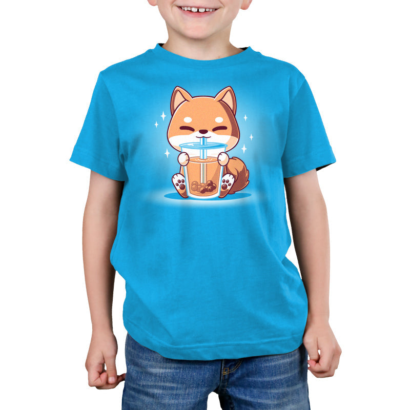 Premium Cotton T-shirt_TeeTurtle Boba Shiba Cobalt Blue t-shirt featuring a cartoon fox happily drinking Boba Shiba from a cup with a straw, set against a blue background with sparkles.