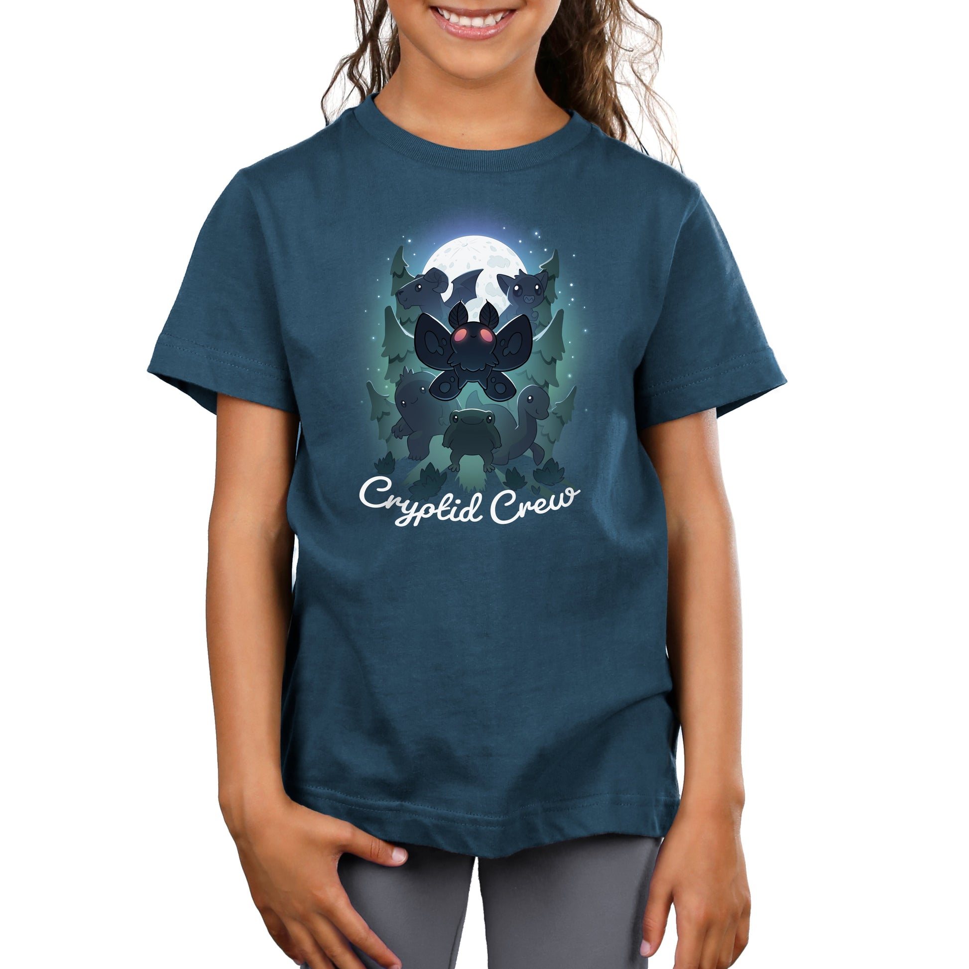 Premium Cotton T-shirt_TeeTurtle Cryptid Crew denim t-shirt featuring a whimsical illustration of six cartoon cryptids, including a mothman and a jackalope, in a forest with a full moon in the background. Text at the bottom reads "Cryptid Crew."