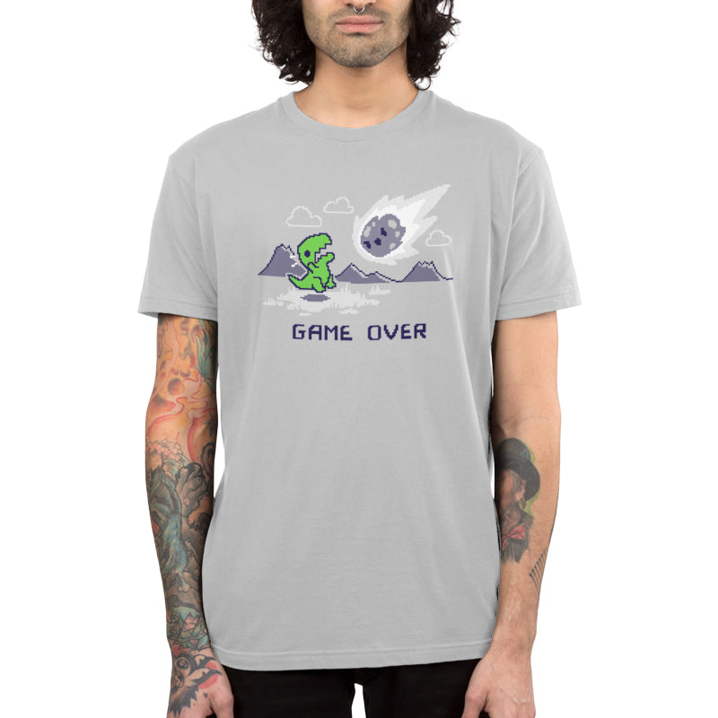 Premium Cotton T-shirt_TeeTurtle Game Over Dinosaur Silver t-shirt featuring Pixel art of a green dinosaur looking at a falling meteor, with mountains in the background