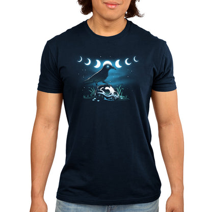 Premium Cotton T-shirt_TeeTurtle Mystical Crow navy blue t-shirt featuring a crow with glowing eyes standing on an animal skull in a grassy area under a night sky.