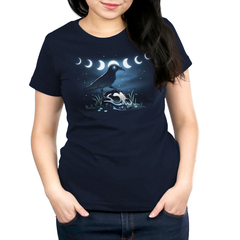 Premium Cotton T-shirt_TeeTurtle Mystical Crow navy blue t-shirt featuring a crow with glowing eyes standing on an animal skull in a grassy area under a night sky.