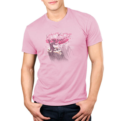 Premium Cotton T-shirt_TeeTurtle Sakura Tree pink t-shirt featuring an illustration of a pink cherry blossom tree on a rocky cliff with mountains in the background. Blossoms and petals are being blown in the wind. 