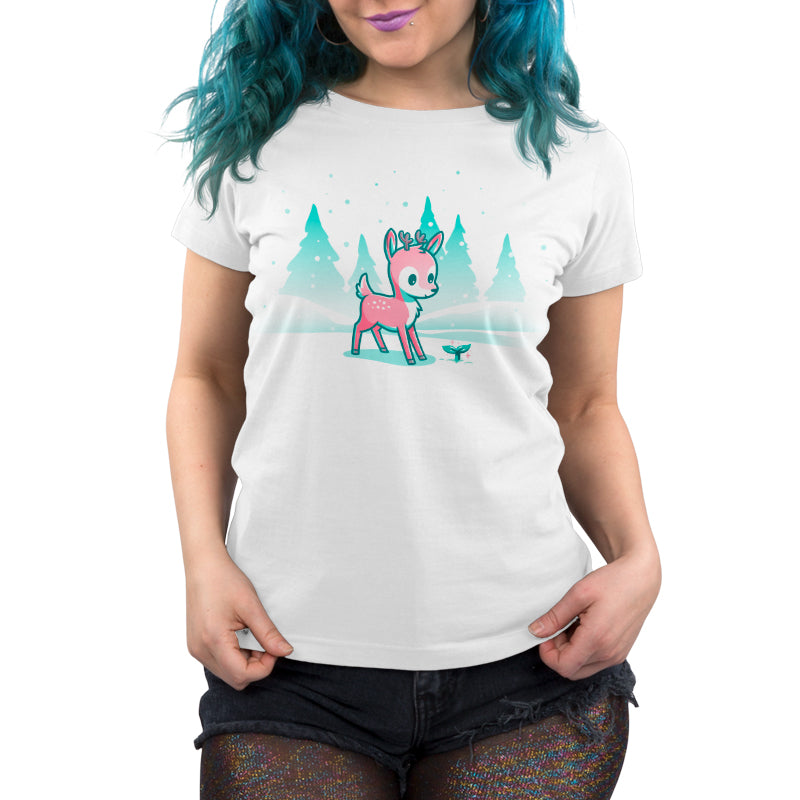 Premium Cotton T-shirt_TeeTurtle Winter Wonderland White t-shirt featuring a cartoon deer with small antlers stands in a snowy landscape with evergreen trees, looking curiously at a glowing sprout on the ground. Snowflakes are falling around them. 