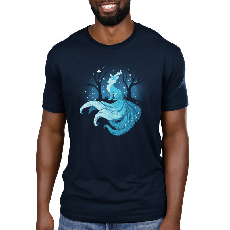 Premium Cotton T-shirt_TeeTurtle Winter Kitsune navy blue t-shirt featuring a blue, fox-like creature with antlers, long tails, and a flowing mane sitting in a snowy forest with bare trees.