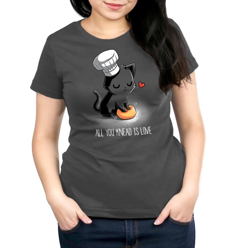 Premium Cotton T-shirt_A cartoon black cat wearing a chef's hat kneads a dough ball, with a red heart above its head, on this unisex tee. Caption reads: "All You Knead Is Love". Made of super soft ringspun cotton, this charcoal gray apparel called "All You Knead Is Love" by monsterdigital is perfect for cat lovers and baking enthusiasts alike.