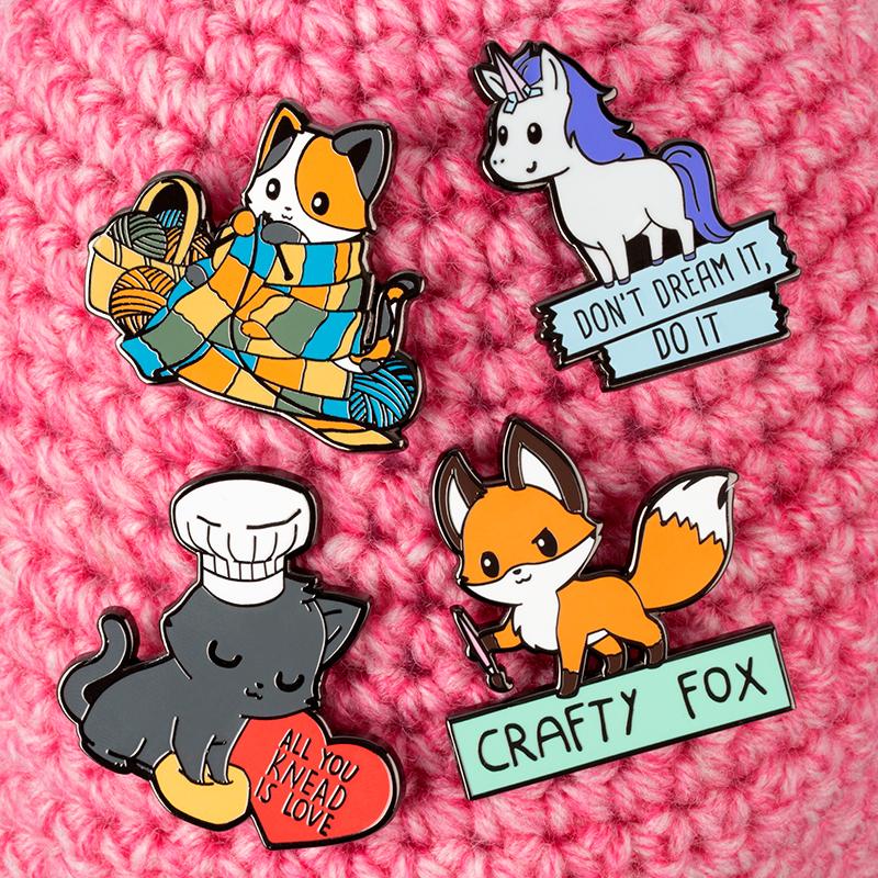 Crafty TeeTurtle knitting kitten enamel pins.