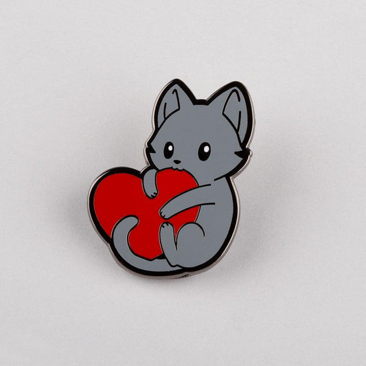 A gray cat holding a red heart 