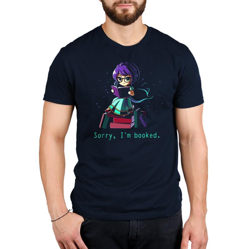 Premium Cotton T-shirt_TeeTurtle navy blue Sorry I'm Booked]. Featuring a girl sitting on a pile of books reading.