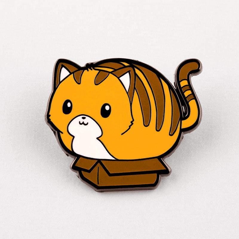 A cat sitting on top of a box, recreated as TeeTurtle's If It Fits, I Sits Pin enamel pin.