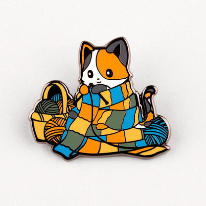 A Knittin' Kitten Pin by TeeTurtle featuring a cat sitting on a blanket.