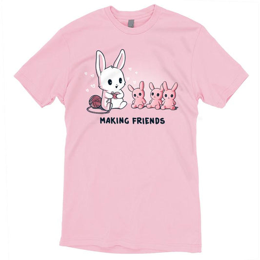 Premium Cotton T-shirt_Teeturtle Making Friends Pink t-shirt Featuring a white-furred bunny knitting bunny friends out of yarn.