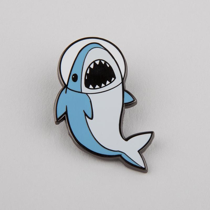 A jaw-some enamel Space Shark Pin with a TeeTurtle shark on it.